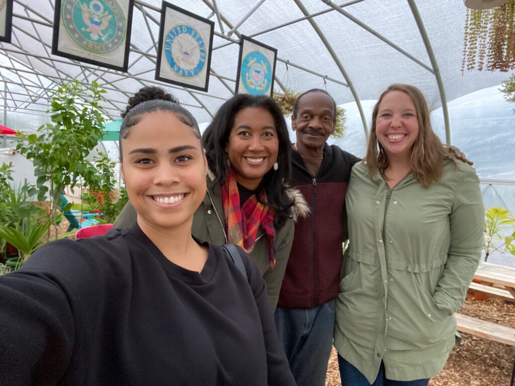 A group of four people inside a greenhouse