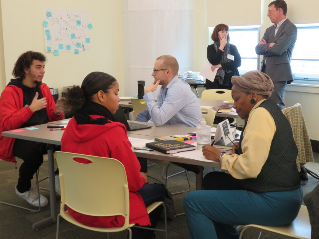 Three different groups of leaders gathered in a room engaged in discussion